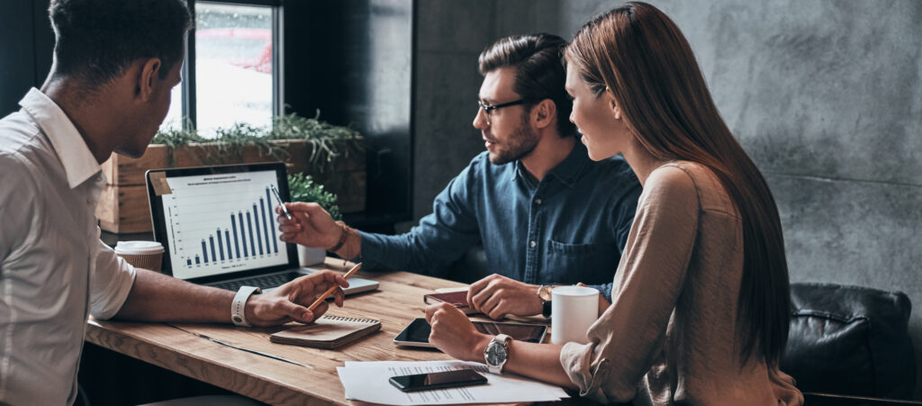 Encouraging Others - Team of people working at a desk and computer