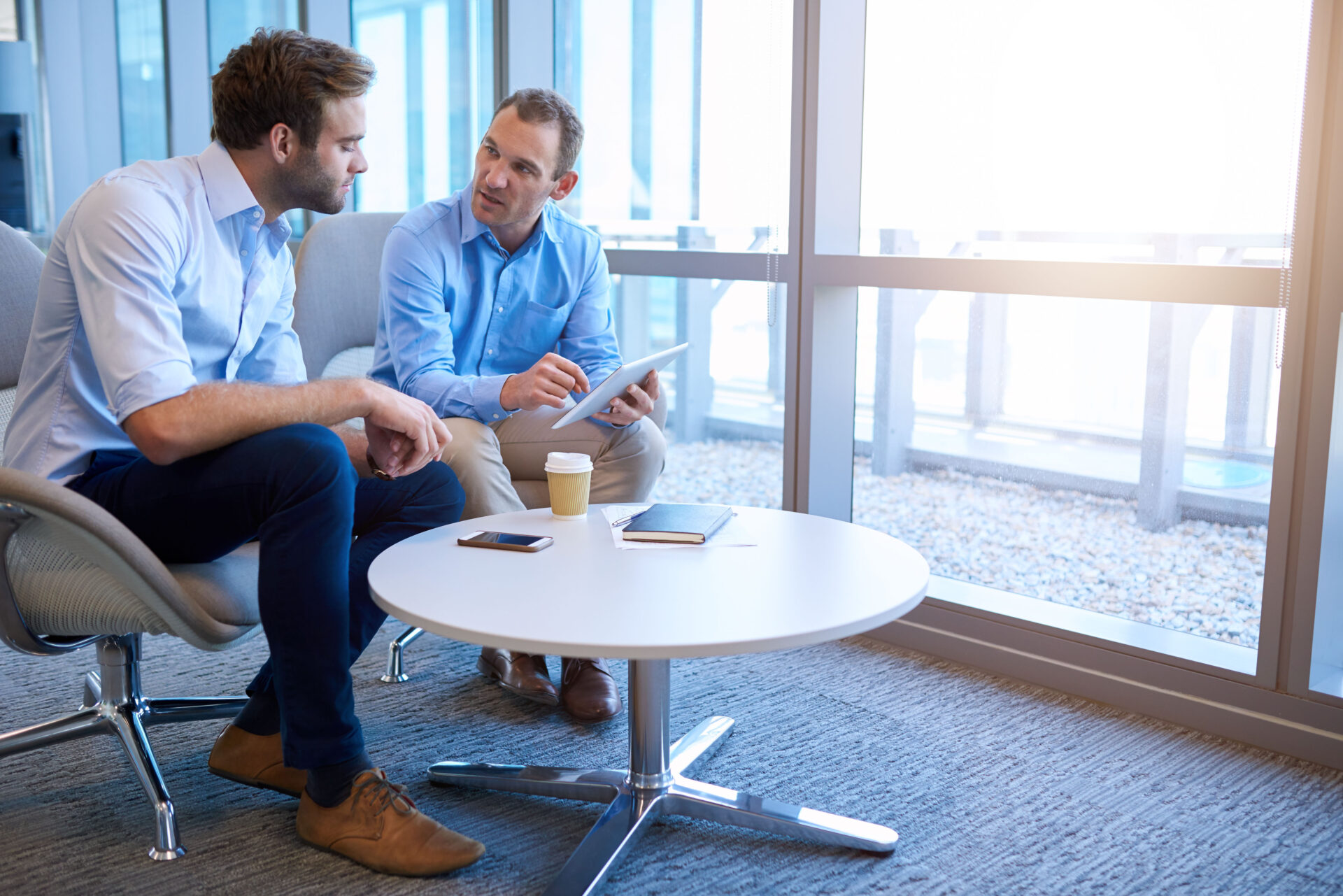 Two men talking at a table in a trustworthy manner