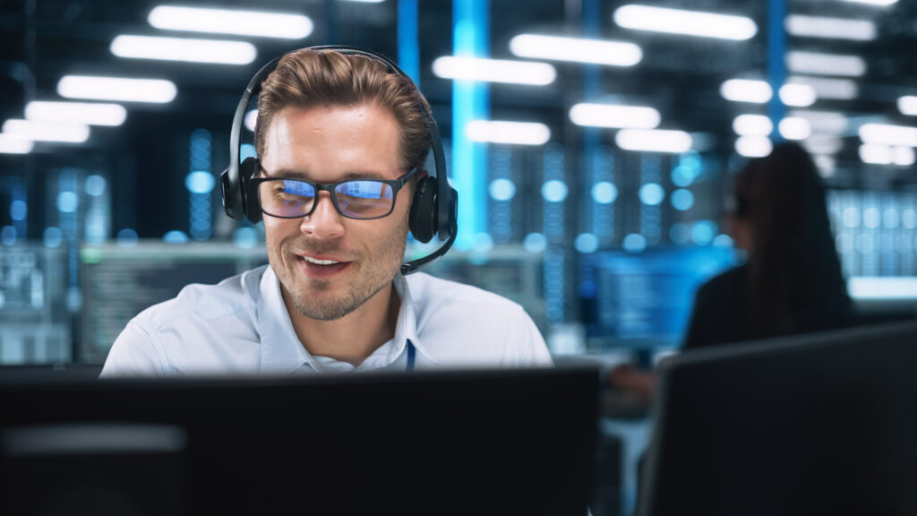 Serious Young Caucasian Man with Headset, Successful Manager of man in front of computer - tech priorities