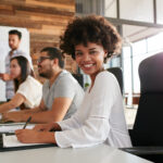 Young black woman sitting at a business presentation about innovation